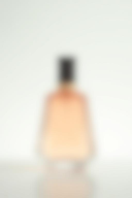 Photographie de produit minimaliste d'une bouteille de parfum sur un fond clair